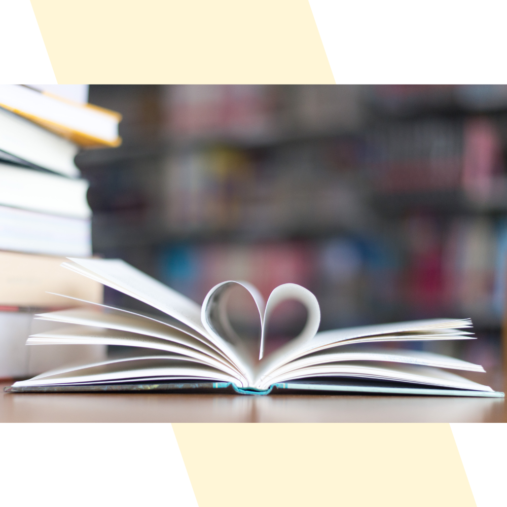 Side view photo of open book with center two pages tucked inward to form a heart shape